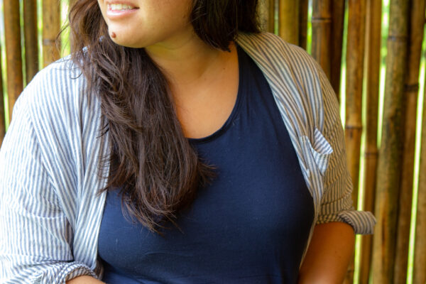 Portrait shot of communications director Kimberly Moa holding a DSLR camera and looking into the distance