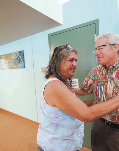 Sharmane Botelho, left, embraced state Health Director Dr. Kenneth Fink on Tuesday at the Iwilei Resource Center.