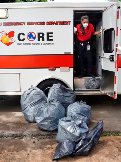 Honolulu CORE team EMT Bethany Nakano in the ambulance, talks with EMS director Jim Ireland, far right, after picking up a homeless patient outside Adventist Health Castle hospital. (Kevin Fujii/Civil Beat/2024)
