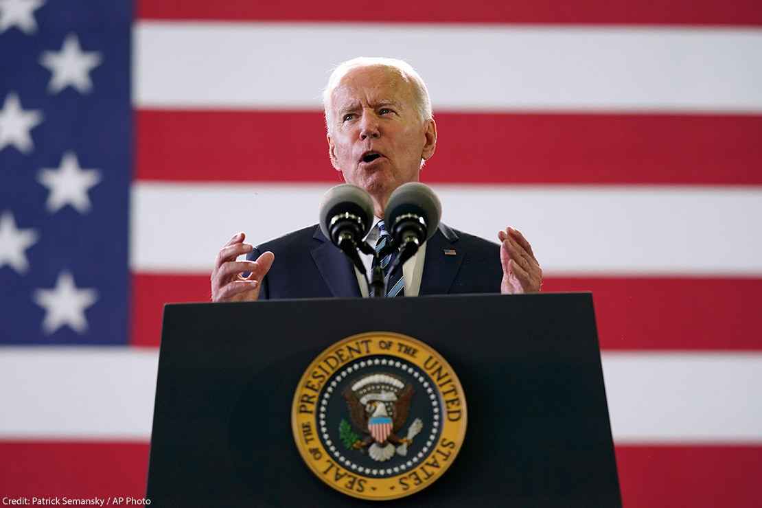 President Joe Biden speaks behind podium to American service members in England