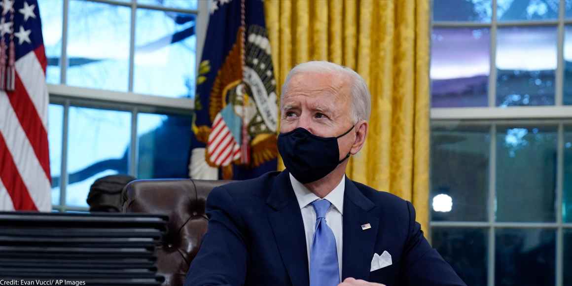 A photo of President Biden in the Oval Office wearing a mask.