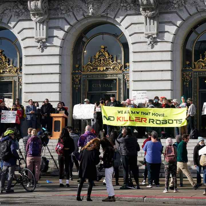 Demonstrators, (holding various signs, with the most prominent reading "WE ALL SAW THAT MOVIE ... NO KILLER ROBOTS") protest the use of robots by the San Francisco Police Department outside of City Hall in San Francisco, Monday, Dec. 5, 2022.