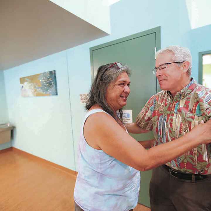Sharmane Botelho, left, embraced state Health Director Dr. Kenneth Fink on Tuesday at the Iwilei Resource Center.