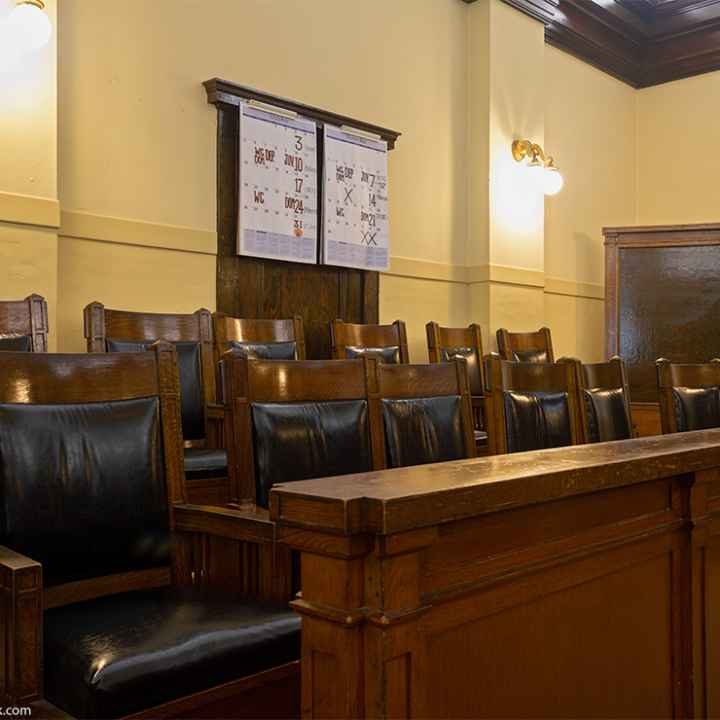 An empty jury box with leather and wood chairs.